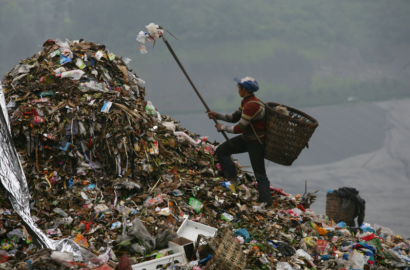 A scavenger picks up plastic bags at an open dump on April 2, 2008 in Chongqing Municipality, China.